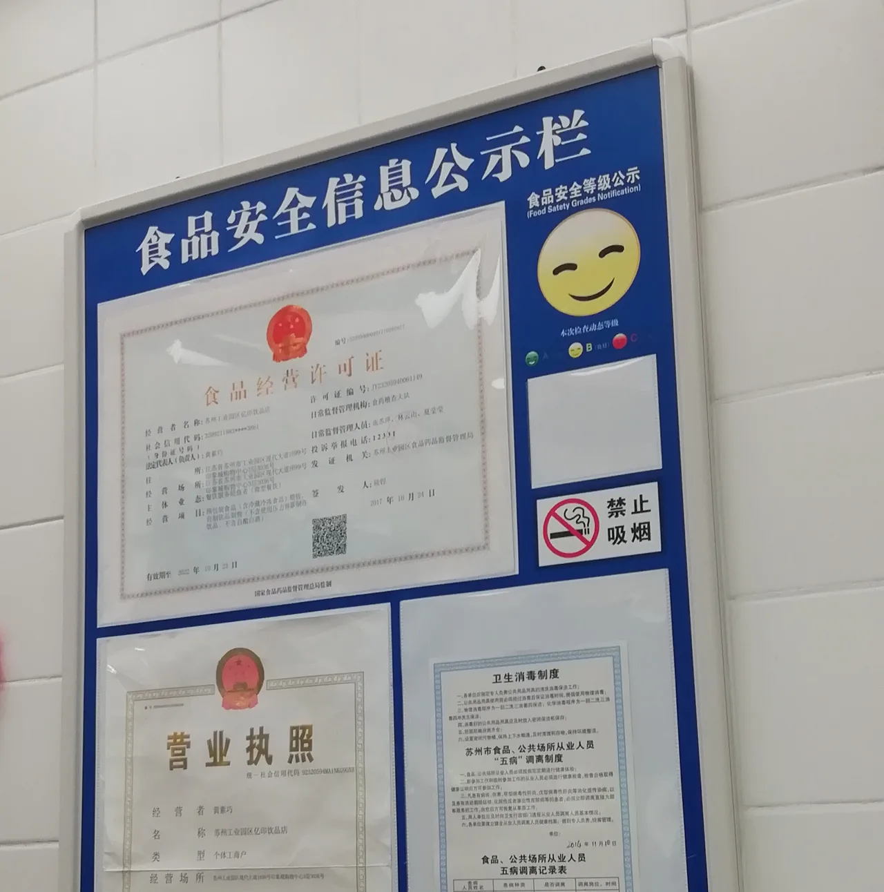 Food safety information board with business and food-operation licences in a tea shop in Suzhou, China